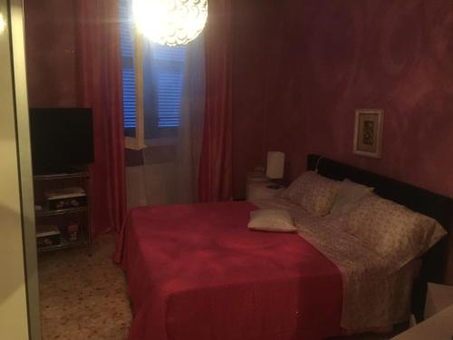 una camera da letto con un letto con un copriletto rosso di Appartamento Porzione di villa "il cappello d'oro" a Chiavari