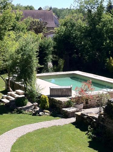 - une piscine avec un banc dans la cour dans l'établissement La chapelle du Domaine, à Saint-Loup-Géanges
