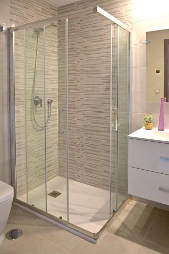 a shower with a glass door in a bathroom at Terrazas de Campoamor by Mar Holidays in Playas de Orihuela