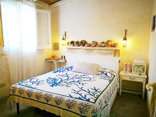 マルサラにあるCasa delle Conchiglieのベッドルーム1室(青と白の毛布付きのベッド1台付)