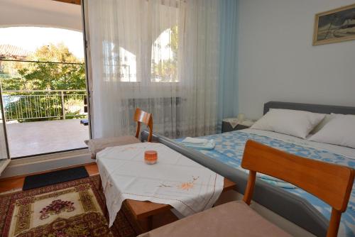 a bedroom with a bed and a table and a window at Apartment Nadica in Punat