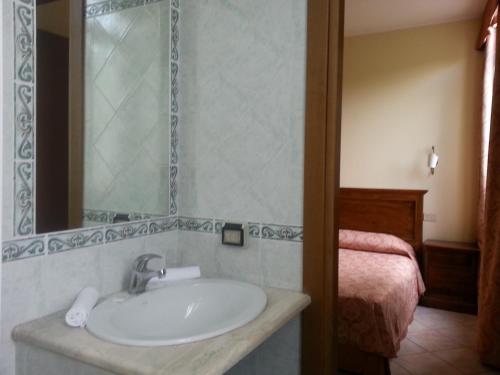 a bathroom with a sink and a bed at Hotel Tempio di Apollo in Olgiata