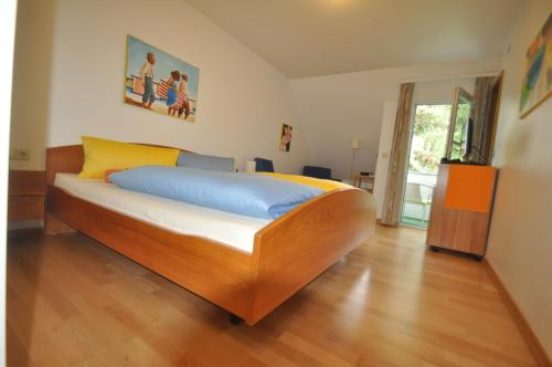a bedroom with a bed with blue and yellow pillows at Apart Hotel Stadtgarten in Überlingen