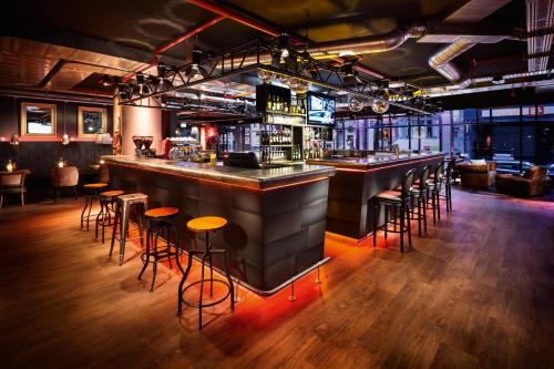 a bar in a restaurant with stools at pentahotel Brussels City Centre in Brussels