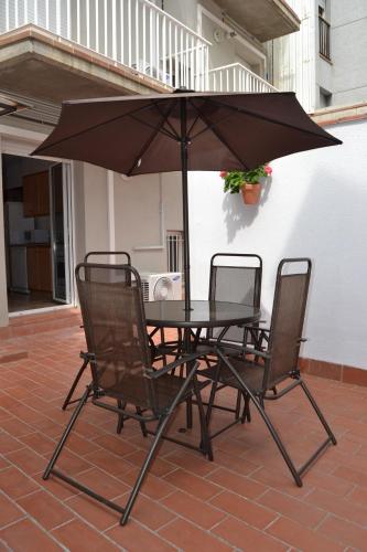 a table and chairs with an umbrella on a patio at Apartments Figueres in Figueres