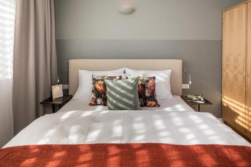 a bedroom with a white bed with pillows at RAFAEL KAISER - Premium Apartments City Centre - Contactless Check-In in Vienna