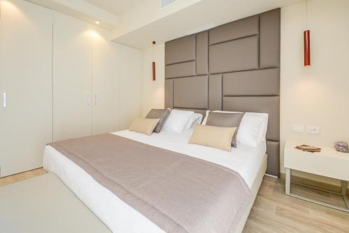 a bedroom with a large white bed and a desk at Hotel Villa Garuti in Padenghe sul Garda