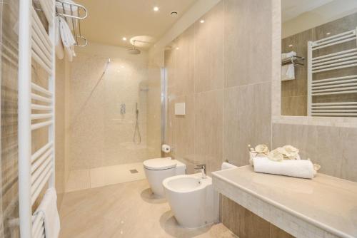 a bathroom with a toilet and a sink and a shower at Hotel Villa Garuti in Padenghe sul Garda