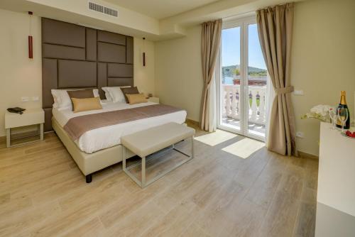 a bedroom with a large bed and a large window at Hotel Villa Garuti in Padenghe sul Garda