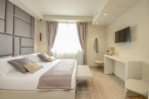 a bedroom with a white bed and a window at Hotel Villa Garuti in Padenghe sul Garda