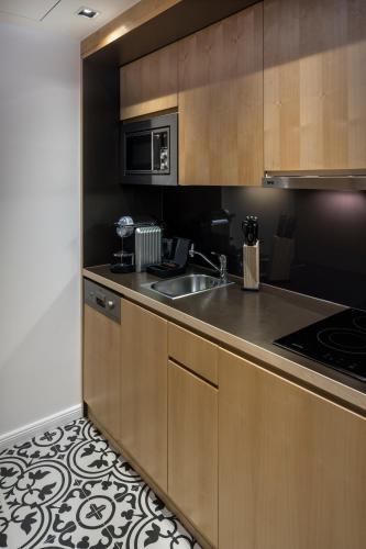 a kitchen with a sink and a microwave at RAFAEL KAISER - Premium Apartments City Centre - Contactless Check-In in Vienna