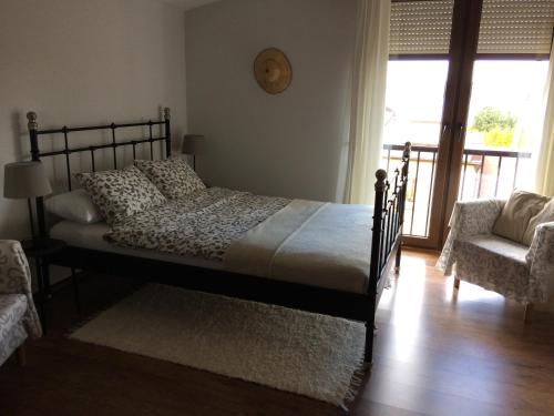 a bedroom with a bed and a chair and a window at Pod lasem in Charzykowy