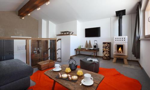 a living room with a couch and a table and a fireplace at Hotel Pashmina Le Refuge in Val Thorens