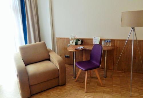 ein Wohnzimmer mit einem Stuhl und einem Tisch in der Unterkunft Brasserie Beierhaascht in Niederkerschen