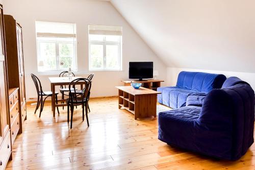 ein Wohnzimmer mit einem blauen Sofa und einem Tisch in der Unterkunft Gästehaus Schloss Plaue in Brandenburg an der Havel