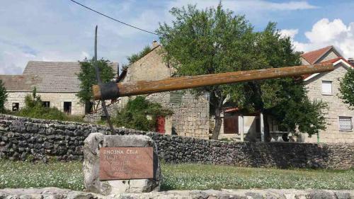 a large wooden pole in front of a house at Apartman Studio Zdravko Eco Village in Imotski
