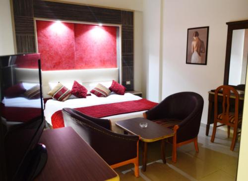 a hotel room with two beds and a table and chairs at Elysee Residence in Beirut