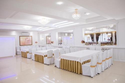 a white room with white tables and white chairs at Boutique Hotel Deluxe in Kamianets-Podilskyi