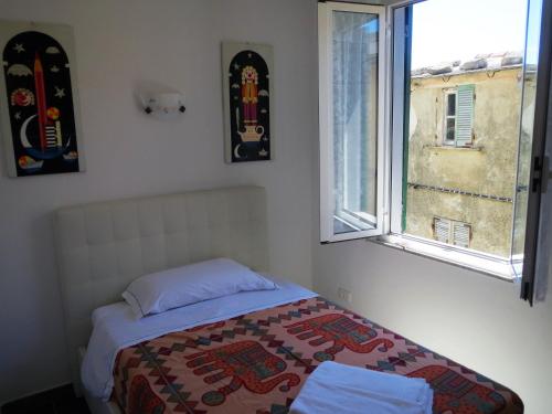 ein Schlafzimmer mit einem Bett und zwei Fenstern in der Unterkunft CREUZA DE 5 TERRE in Volastra