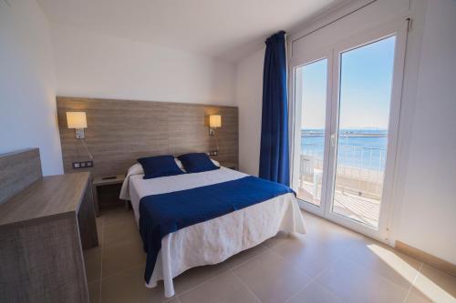 una camera da letto con un letto e una grande finestra di Hotel Risech a Roses