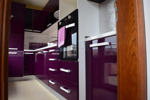 una cocina con armarios morados en Kalina Family Hotel, en Burgas