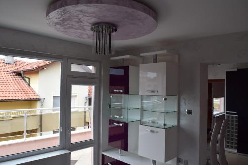 Habitación con ventana y lámpara de araña. en Kalina Family Hotel, en Burgas