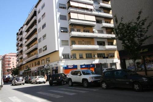 uma rua da cidade com carros estacionados em frente a um edifício alto em Maison Velia em Roma