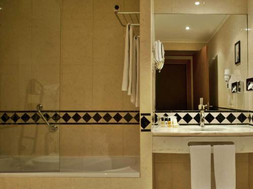 a bathroom with a sink, toilet and bathtub at TURIM Europa Hotel in Lisbon