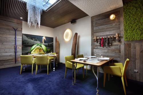 a dining room with wooden walls and tables and chairs at Hotel Pashmina Le Refuge in Val Thorens