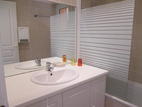 uma casa de banho com um lavatório e um espelho em Résidence AMARINE em Capbreton