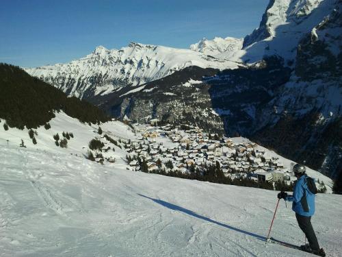 a person is skiing down a snow covered mountain at Hotel Alpenblick Mürren in Mürren