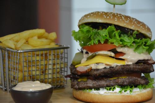 a hamburger and fries and a basket of french fries at Hotel Cesarski - Kaiserhof in Giżycko