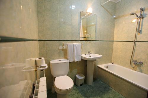 a bathroom with a toilet and a sink and a bath tub at Hostal San Blas in La Alberca