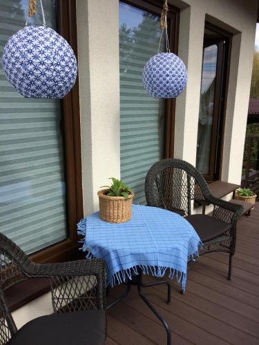 a table and chairs on a porch with lights at Pod lasem in Charzykowy
