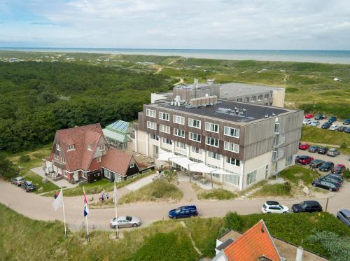 an aerial view of a large building with a parking lot at Grand Hotel Opduin in De Koog