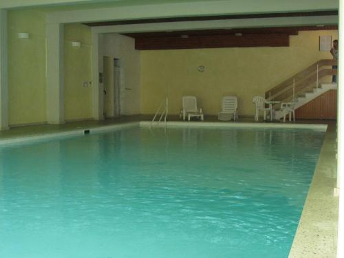 ein großer Pool mit Stühlen in einem Gebäude in der Unterkunft Casa Irmella 16 in Arosa