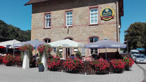 a restaurant with umbrellas and flowers in front of a building at FeWos im alten Bahnhof in Lauterecken