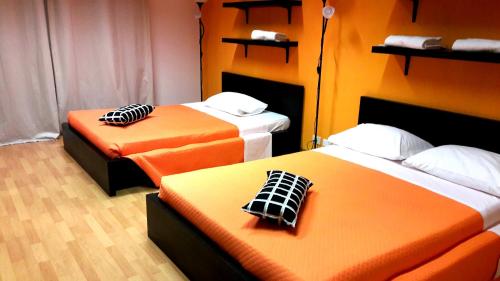 two beds in a room with orange and white at Guest House Pirelli Milano in Milan