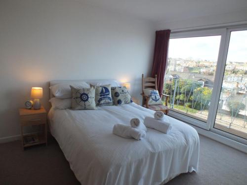 a bedroom with a white bed with two teddy bears on it at Sea Crest in Brixham