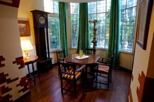 a dining room with a table and chairs and a clock at Affittacamere Villa Wilson in Rome