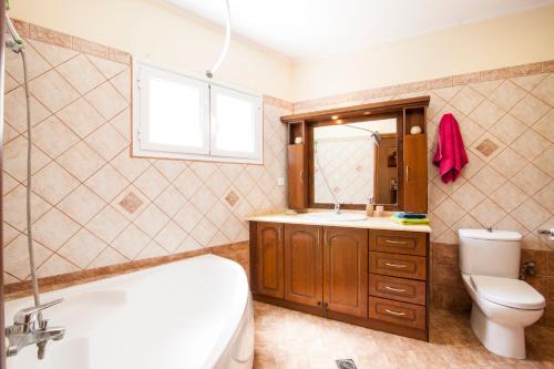 a bathroom with a tub and a toilet and a sink at Harmony Marathias luxury apartment in Marathias