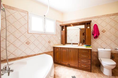 e bagno con vasca, servizi igienici e lavandino. di Harmony Marathias luxury apartment a Marathias