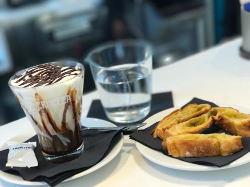 a plate of food with a milkshake and waffles on a table at DubaiVillage in Camposano