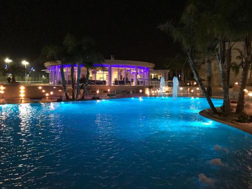 a swimming pool at night with blue lights at DubaiVillage in Camposano