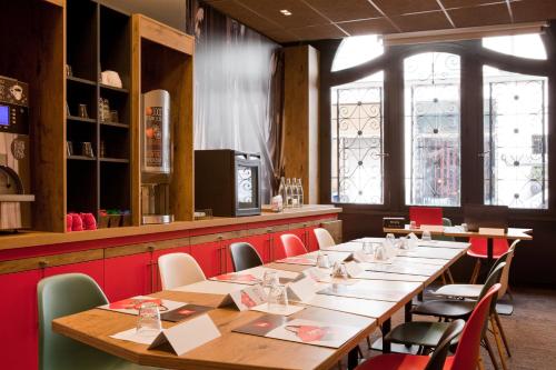 une salle à manger avec une longue table et des chaises dans l'établissement ibis Paris Gare De L Est 10ème, à Paris