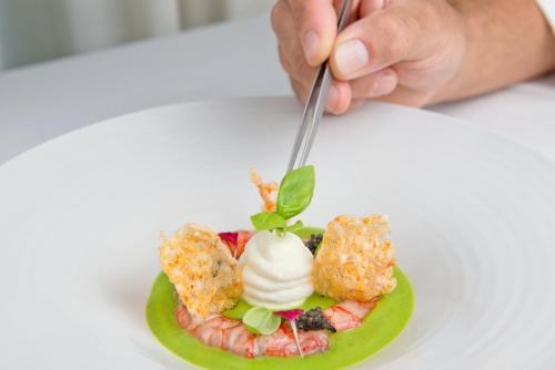 a person eating a plate of food with a spoon at Swiss Diamond Hotel & Spa in Morcote