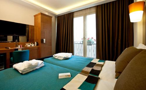 um quarto de hotel com uma cama com toalhas em Collage Taksim Hotel em Istambul