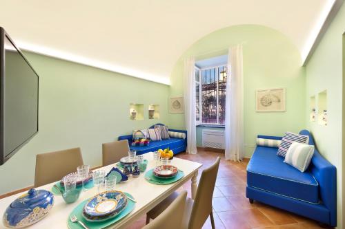 una sala da pranzo con tavolo e sedie blu di Estate4home - Henry House a Sorrento