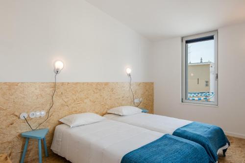 クアルテイラにあるHostel Conii & Suites Algarveのベッド2台と窓のある寝室