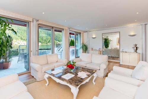 a living room with white couches and a table at Swiss Diamond Hotel & Spa in Morcote